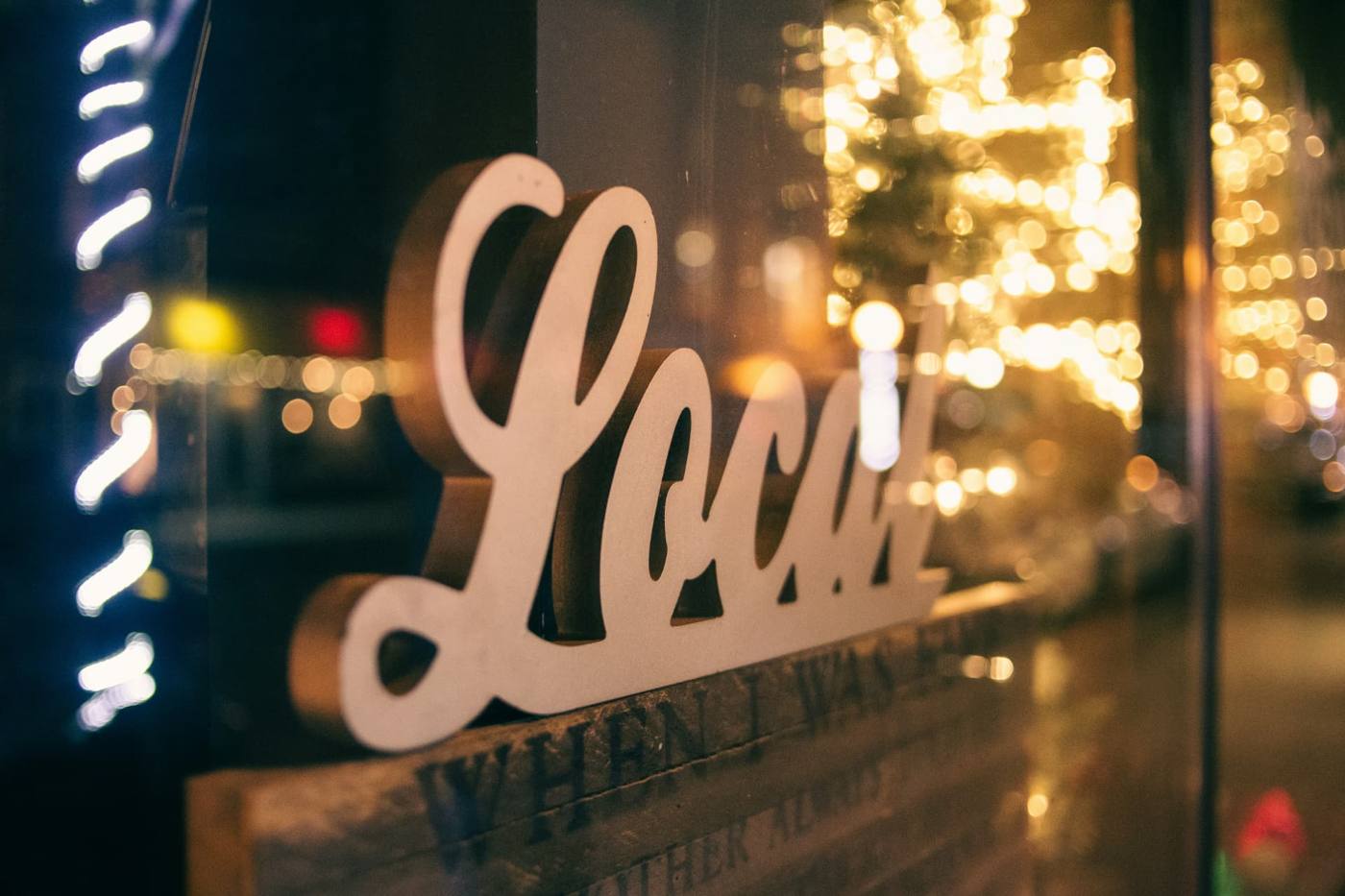 Decorative Local sign in a lit storefront window at night, representing local SEO