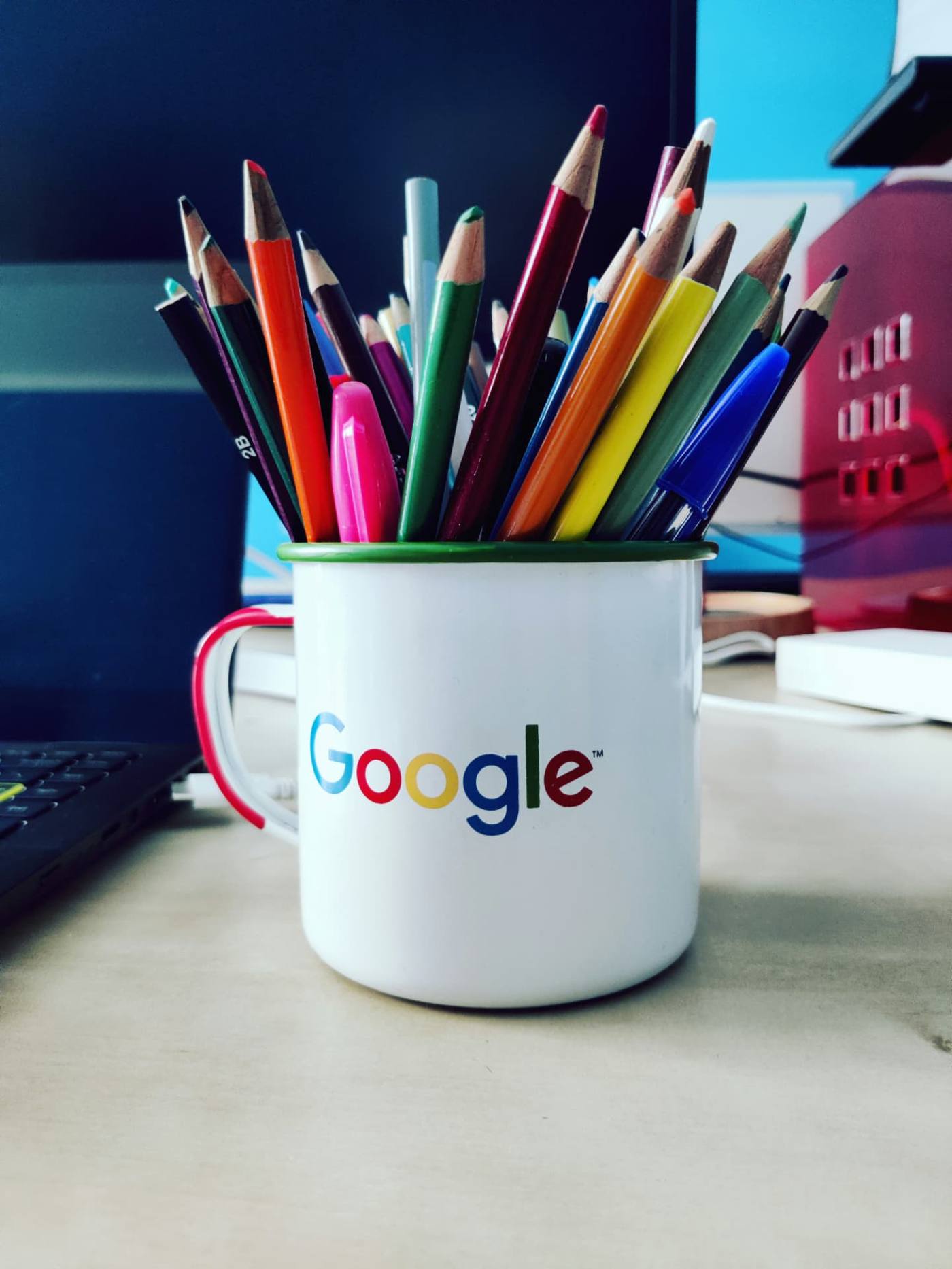 Colored pencils in a Google branded mug on a desk, representing hands-on Google Business Profile upkeep