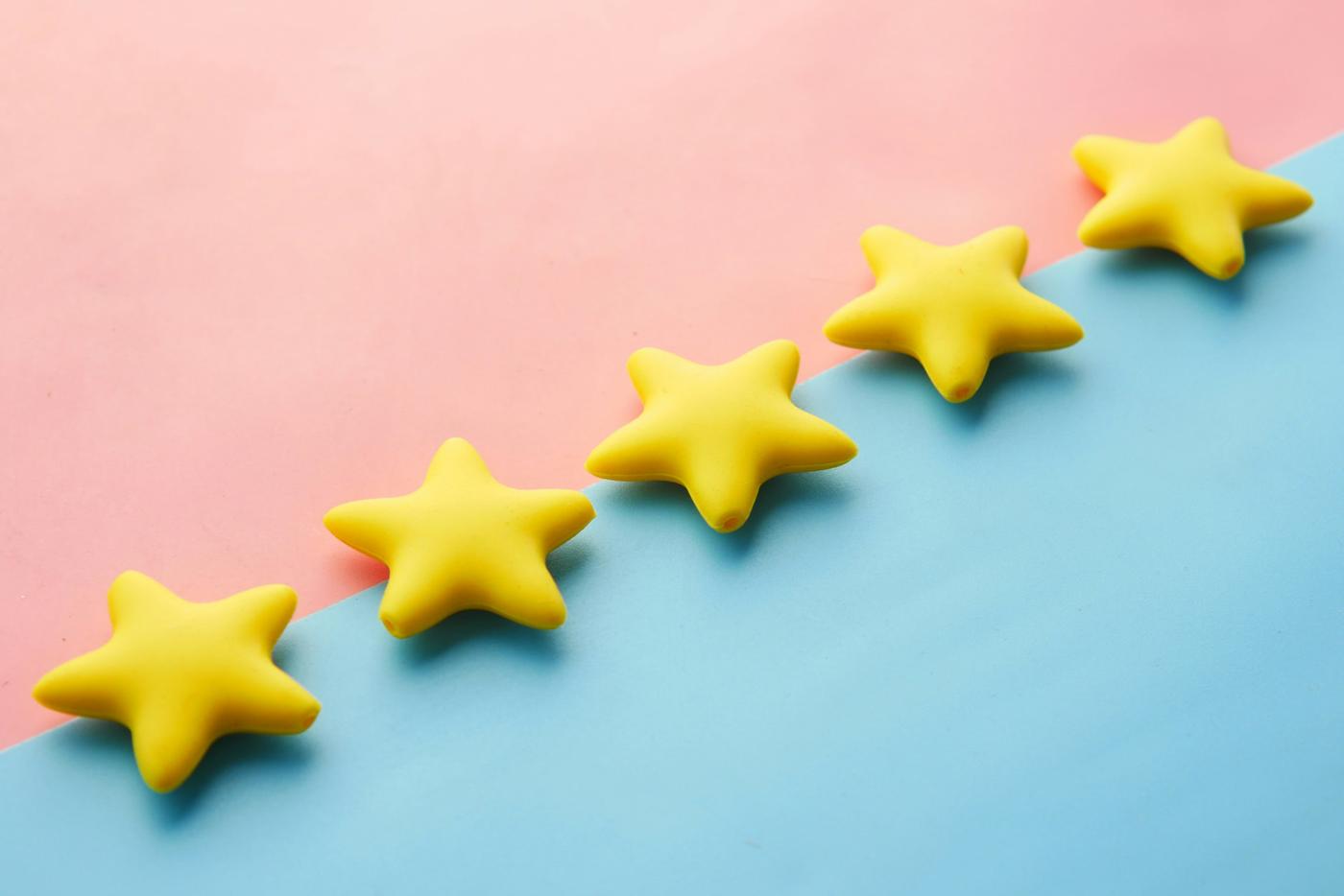Five yellow star ratings on a pink and blue background, representing online review ratings